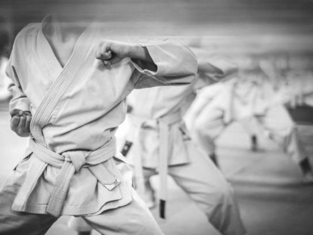 Elbow punch in karate. Children's training. Black and white photo with film grain effect.